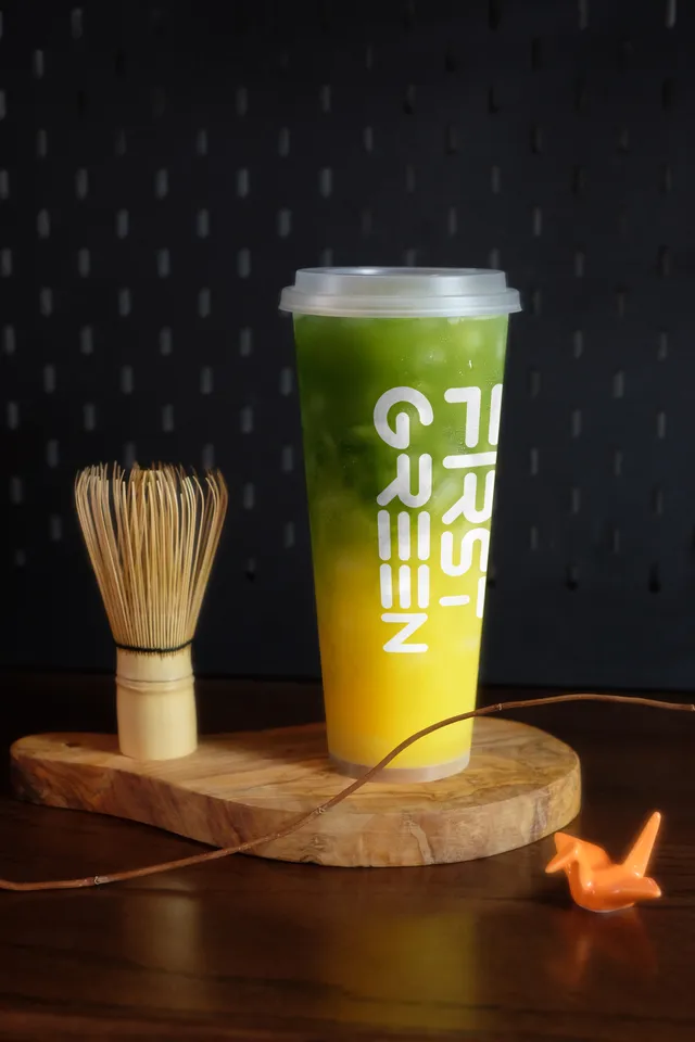 Green and yellow matcha fruit tea with a whisk
