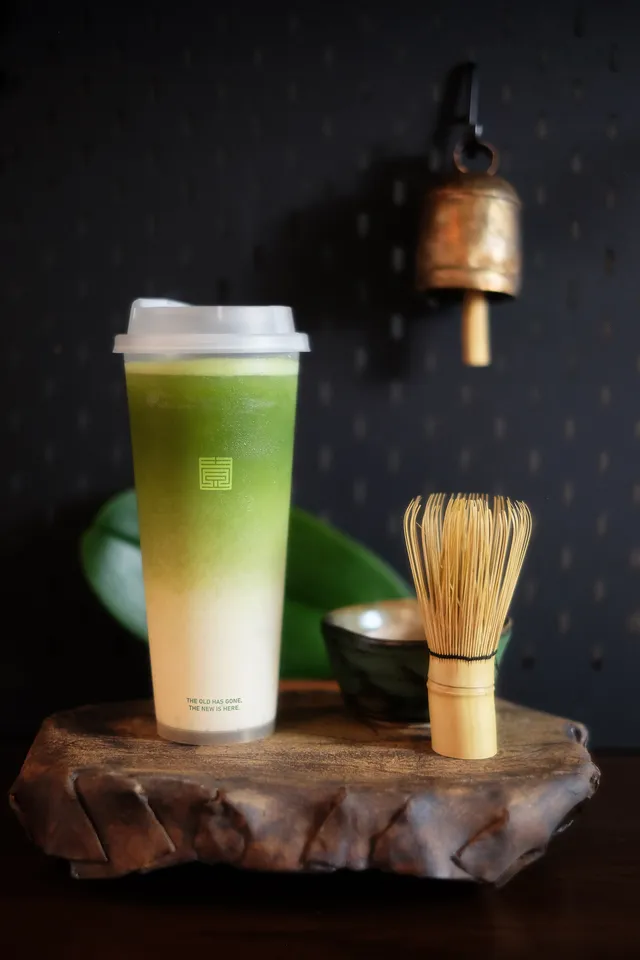 Matcha latte with a bamboo whisk